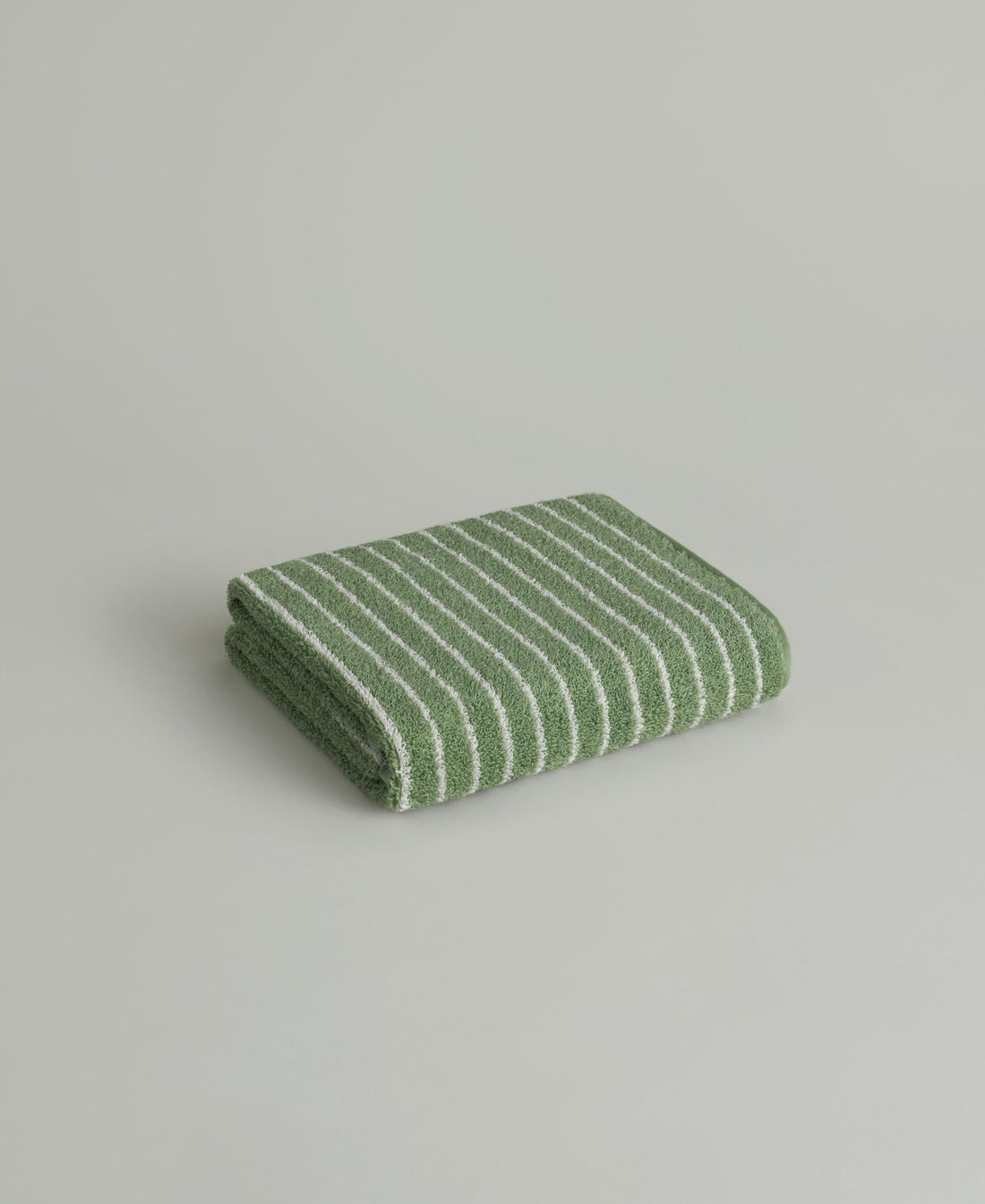 A Sage Stripe Korean face towel from TheGrann, folded — a housewarming gift from Litko in Dallas