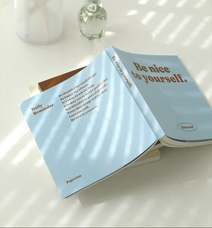 Two light blue books with motivational text on a white surface